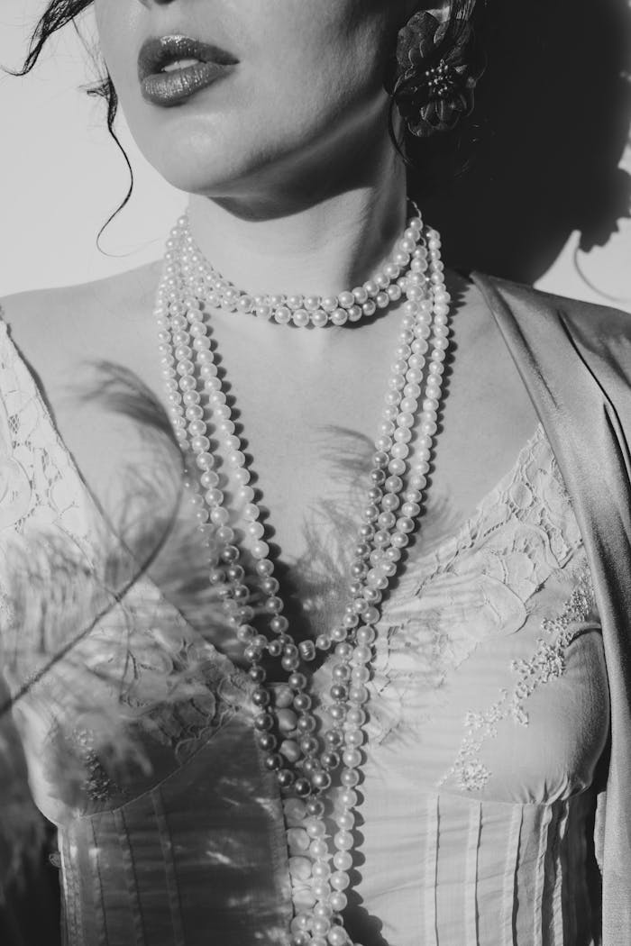 A woman in a dress with pearls and a necklace